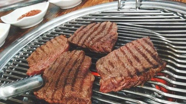 
                        烤牛肉
韓國的牛肉都非常貴，自選的標好價格的牛肉，每盒大概三萬韓幣左右，純牛肉來回翻滾烤熟會有一陣香味。依舊用剪刀剪成小碎塊，韓國很多人都會烤肉哦而且技術很精湛，跟韓國的朋友們一起吃飯?zhí)貏e開心因為他們都很會照顧人。
