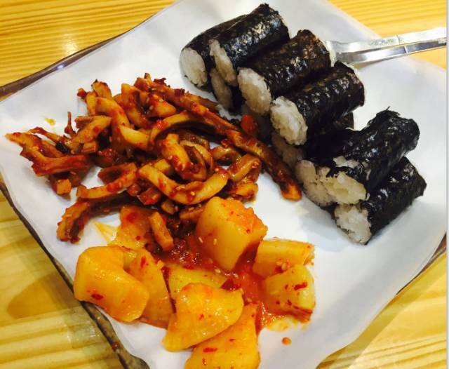 
                        明洞忠武紫菜包飯
吃這紫菜包飯的時候通常是配上用鹽，辣醬和醋腌制好的魷魚一起食用。這家店在紫菜包飯中加入了獨有的秘方使其更有滋味和嚼頭，而且這家的配菜辣章魚更是讓人贊不絕口，鮮美的辣章魚只要買紫菜包飯就可以免費吃哦。