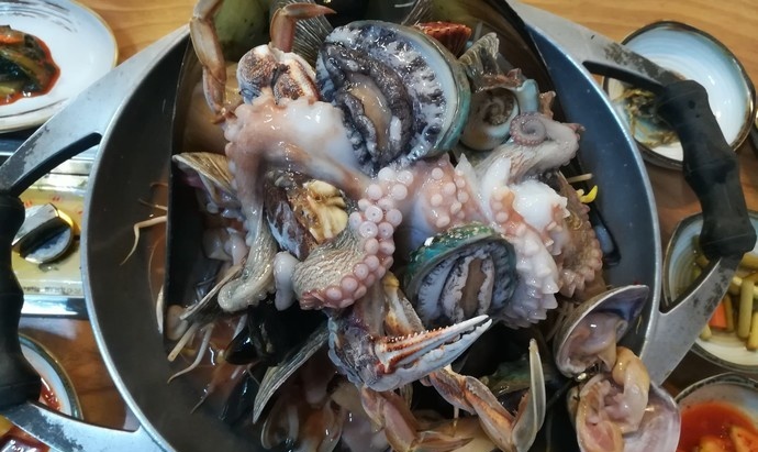 
                        #韓國美食#三姓穴海鮮湯是濟州島很有名的海鮮鍋專門店。滿滿一鍋海鮮，味美料足，小鮑魚、扇貝、螃蟹、章魚、蛤蜊等不少新鮮的海鮮。吃完海鮮就還會下一份烏冬和青菜進去！真的是超級美味~