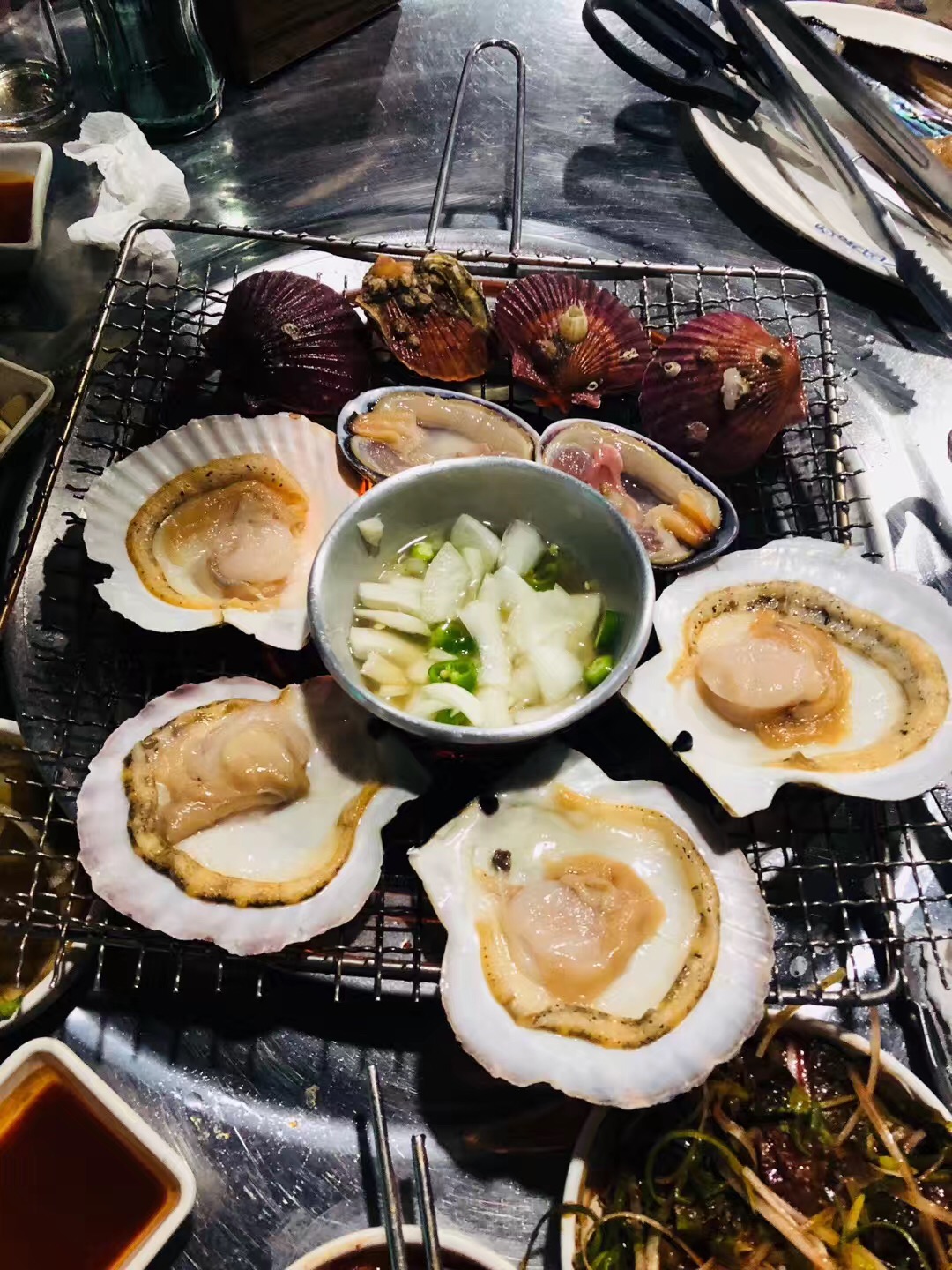 
                        這家烤扇貝在韓國(guó)釜山一號(hào)線南山7號(hào)出口，出來以后沿著BR冰淇淋店直走路過迷你島便利店的時(shí)候往左手邊走，在馬路對(duì)面即可看到店名是???? ???? 這個(gè)點(diǎn)的是2人份套餐在這個(gè)基礎(chǔ)上還會(huì)有五花肉等肉類，肉烤完之后會(huì)給上扇貝的。
小菜給的也很多，有雞蛋羹，還會(huì)給海紅，還有魚子醬拌飯等，兩人點(diǎn)的話完全是夠的~他家大醬湯也是蠻好吃的~推薦給各位來釜山游玩的親故們~人均差不多120左右~
