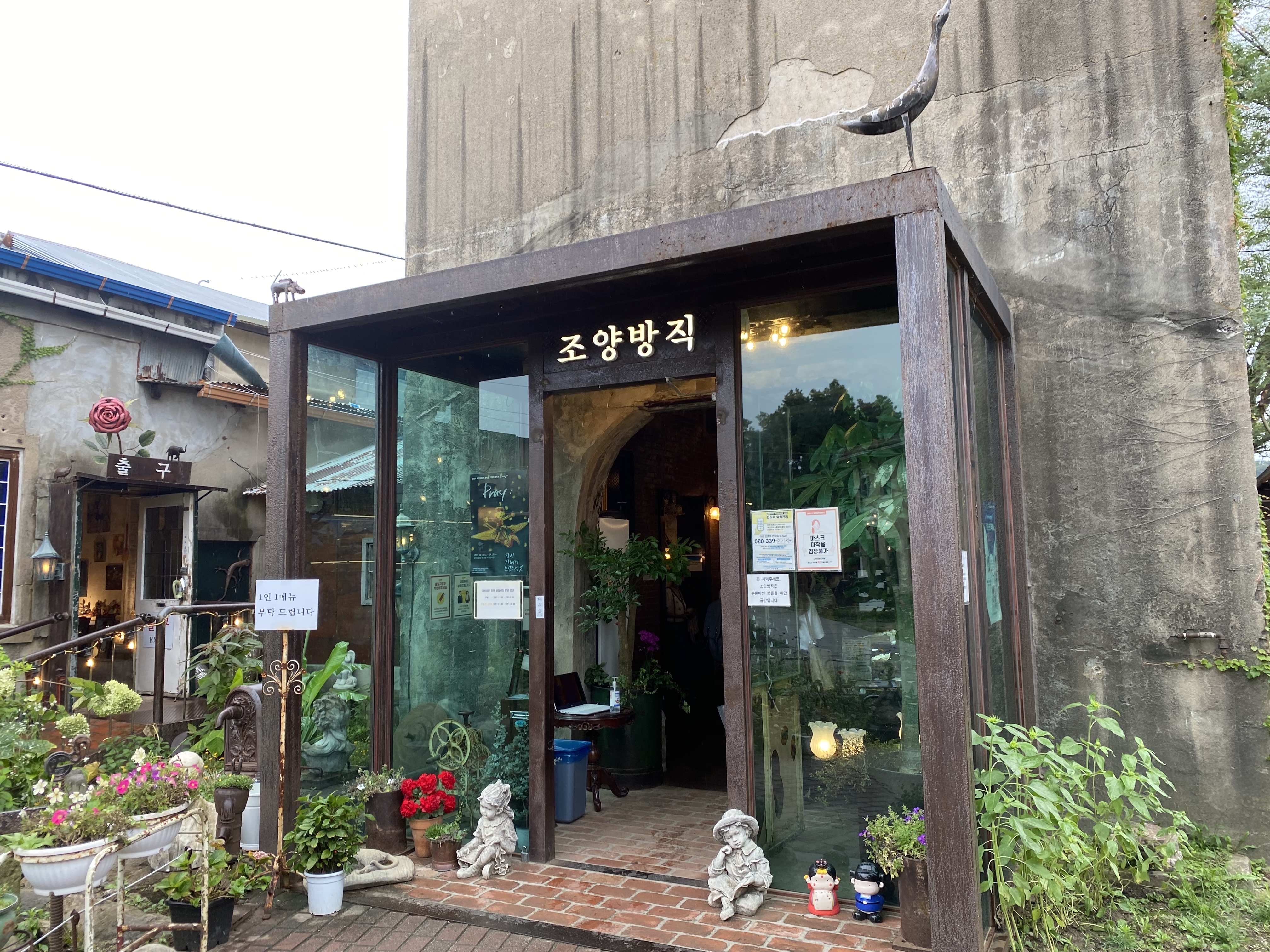 
                        韓國仁川江華島---復古美術館大型咖啡廳，朝陽紡織（????）這是一家舊紡織廠改造的咖啡廳，有一些北京798藝術區的感覺。是于1933年設立的江華島最大的紡織工廠。不過隨著歲月的流逝，江華紡織品衰落，便淪落為了廢宅。如今重生為了一家大型咖啡廳&美術館。當初長長的工作臺變成了咖啡桌，咖啡廳內的空間被世界各地的古董所填滿，每一件物品都有自己的故事。走進這間大型咖啡廳，會禁不住的感嘆。大規模格局的設計風格和多種多樣的收藏品，每個角落都藏滿了小心思，處處都有驚喜的感覺。 #江華島##江華島咖啡廳##仁川江華島# 這里的咖啡會稍微貴一些（韓幣7000元以上），但是逛過一圈過后，就會發現絕對不虧！室內室外拍照出片率都極高，就算下雨也別有韻味，而且泡上一天都不會無聊。可以先找好座位坐下來歇一歇，然后再去拍照，每個房子每個角落都不要錯過，包括洗手間！也能帶來不一樣的感覺。復古愛好者絕對不要錯過。?地址：仁川江華郡江華邑新門里587（?? ??? ??? ??? 587）電話：0507-1307-2192時間：周一-周五，11-20點；周末&公休日，11-21點