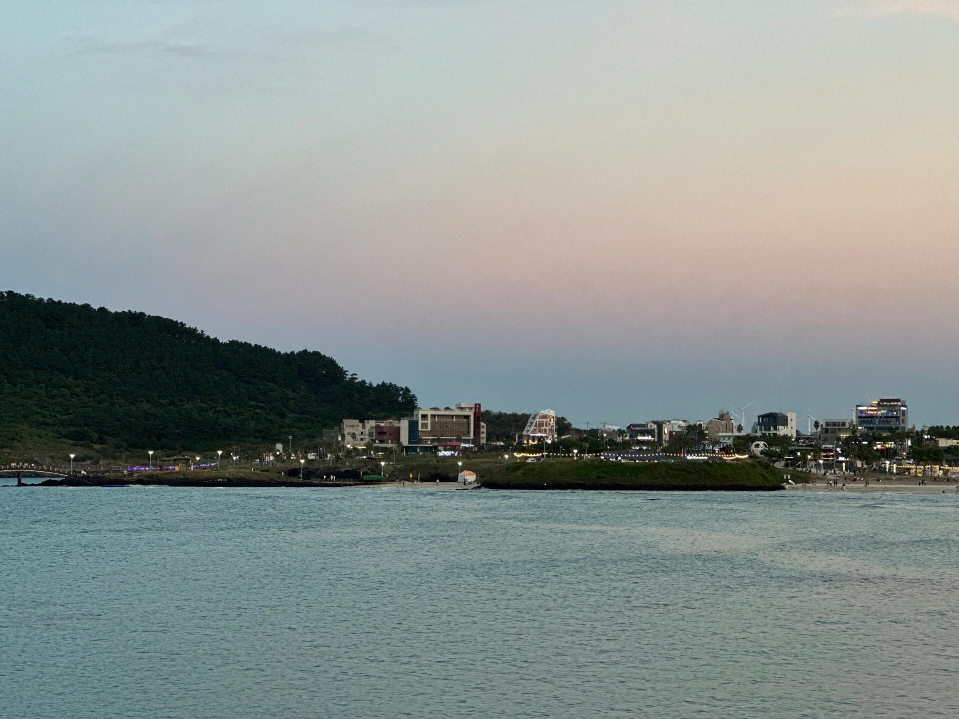 
                        ?? 傍晚西歸浦/ JEJU海岸村恰恰恰 ??#濟州島 #西歸浦 #咸德海水浴場 #JEJU?? 當夕陽灑落在JEJU的海岸線上，西歸浦的海岸村仿佛被金色的光輝所包圍。這里不僅是濟州島上的一個寧靜港口，更是一個充滿活力的小村莊，每當傍晚時分，村里的居民和游客都會聚集在咸德海水浴場，享受海風和海浪的擁抱。??? 咸德海水浴場以其清澈的海水和細膩的沙灘而聞名，是一個完美的放松和游玩的去處。無論是漫步在海邊，還是坐在沙灘上看著日落，都能讓人感受到大自然的壯麗和生活的美好。?? 不要忘了帶上你的相機，因為這里的每一處風景都值得記錄下來。從海岸線的自然美景到村莊里溫馨的小店，每一幕都是獨一無二的記憶。??? 當然，來到這里，你也不能錯過品嘗當地美食的機會。海岸村的餐廳提供新鮮的海鮮和地道的韓國料理，讓你的味蕾也能享受一場旅行。?? 隨著夜幕的降臨，西歸浦的海岸村依舊熱鬧非凡。小巷中傳來的音樂聲，海浪拍打著岸邊的聲音，還有遠處燈火通明的漁船，共同譜寫著濟州島夜晚的恬靜與美麗。?? 讓我們在JEJU的海岸村留下腳步，感受這份獨特的韓式浪漫吧！??