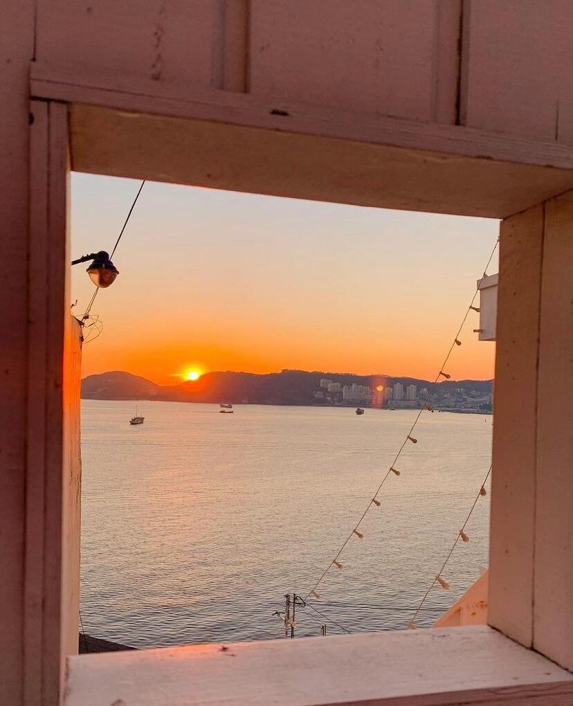 
                        釜山影島夕陽海景咖啡廳-Aether咖啡廳?最近和閨蜜踏上了釜山的旅程，首站就選中了網紅Aether咖啡廳，聽說這里的夕陽美得不可思議，我們決定來驗證一番！??下午時分，這里已經是摩肩接踵，想要拍個無人的美照簡直是挑戰極限??。咖啡廳內部裝修簡潔大方，面朝大海的全景玻璃墻讓人心曠神怡。戶外區域更是可以近距離感受海風拂面，海浪輕拍的自然旋律。坐下來，和朋友邊聊天邊享用香醇咖啡，不知不覺間夕陽開始緩緩下沉。那一刻，天空和海洋被染上了金紅色，美得讓人屏息。夕陽的余暉映照在海面上，美景如畫，讓人完全明白為何這里是釜山必打卡的網紅咖啡廳。??如果你來釜山，一定要來Aether咖啡廳體驗這份寧靜與美麗，超級推薦！??實用信息??地址：釜山廣域市影島區絕影路234??餐點價格：美式咖啡 5,800韓幣，香草煉乳拿鐵 7,000韓幣??營業時間：10:00-21:00，20:00停止點餐#韓國 #釜山 #釜山旅行 #釜山美食 #咖啡店 #旅途中的美景 #夕陽 #海景 ????