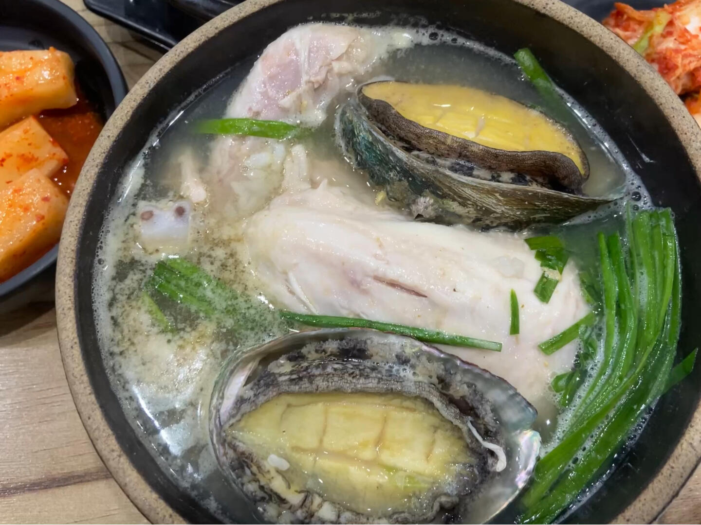 
                        救命??濟州島西歸浦大補參雞湯太上頭了！本來想去吃海鮮湯，結果那家店沒開門，就去了旁邊的參雞湯店。里面都是本地的爺爺奶奶在開老伙伴party，一人一鍋參雞湯，邊吃邊聊。店家只賣參雞湯，有三個品種：純參雞湯、藥膳和鮑魚。我們兩個人點了一個原味和一個鮑魚，鮑魚超級大，很新鮮。我住在海邊，感覺西歸浦的鮑魚海味更重一些，更嫩，品質不錯。參雞湯很清爽，不是濃郁的風格，不像廣東老火湯，里面有大蔥，配合鮑魚入口比較清甜，冬天喝一碗真的絕了！店家的菜單上說用的是澳洲土雞，吃起來和國內的差不多。重頭戲來了，店家送了兩根參和一瓶參酒，店員特意交代我們說參很補，連葉子都可以吃。我們想著別浪費，就體驗了一下。吃完飯再吃的參，好家伙，一吃完就覺得身體有一種洪荒之力噴涌而出，真的沒有夸張，很上頭，感覺可以立馬去跑個八百米。晚上還去散步了兩個小時才回酒店，然后，誰知道，當天晚上凌晨三點眼睛瞪的像銅鈴，第二天繼續玩也像打了雞血一樣興奮。甚至第二天晚上也沒睡著。媽呀，我看那么多小紅書也沒見別人說參雞湯威力這么大呀！韓國人真的不用睡的嗎。視頻里面碗上有店名，想試試大補的小伙伴可以勇士前往一品高下！味道還是很正宗的哈哈！店就在我們住的酒店旁邊，酒店是casaloma hotel。#韓國人不睡覺 #西歸浦 #參雞湯 #西歸浦美食 #西歸浦旅行 #濟州島 #濟州島旅行 #濟州島自由行 #西歸浦參雞湯 #進補