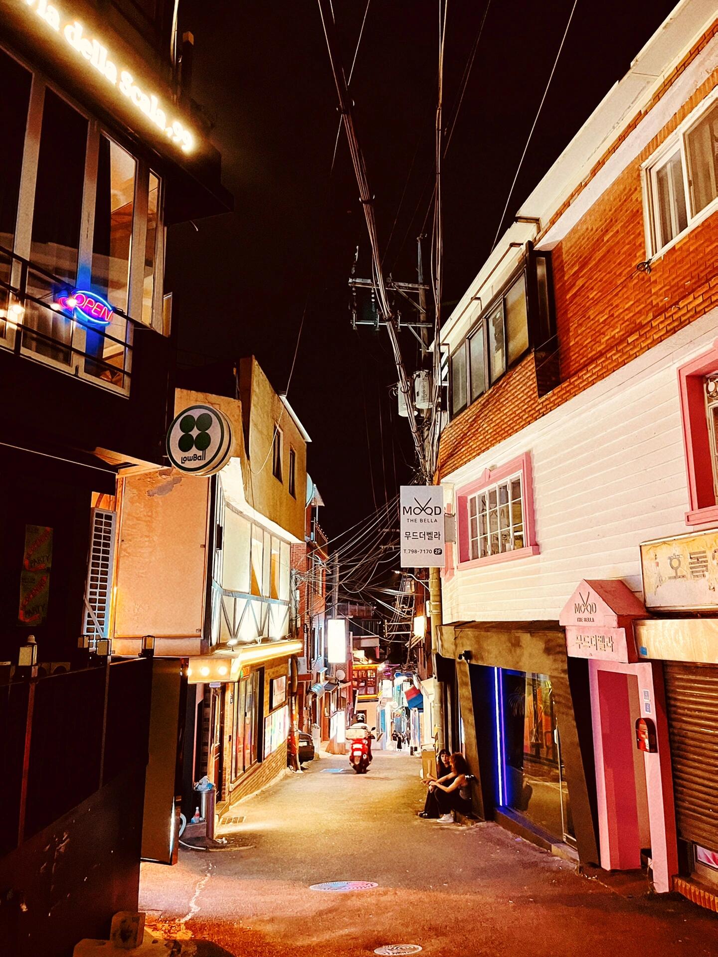 
                        首爾｜梨泰院的夜生活指南#探店 #旅游 #攻略 #拍照 #打卡 #梨泰院 #梨泰院ClASS #梨泰院夜店從明洞出發，搭乘公交車悠閑地經過南山塔，到達梨泰院站下車。從King夜店旁的小巷子一路走進去，就能感受到梨泰院的獨特魅力啦！?我們隨機選擇了一家名為Waikiki的酒吧（見P5-6），坐下感受這里的氛圍。老實說，酒的味道比較普通，杯子也是塑料材質，但這里的氛圍真的很棒！??相比新天地，這里喝酒的人顯得更加妖嬈多姿。由于沒有提前預約，我們只能坐在露臺的位置。起初我還覺得奇怪，明明這種位置更舒適啊！后來才發現，內場的氣氛非常熱烈，充滿了各種魔性舞蹈的人群！??音樂聲震耳欲聾，我個人覺得比弘大的pub要好太多了！